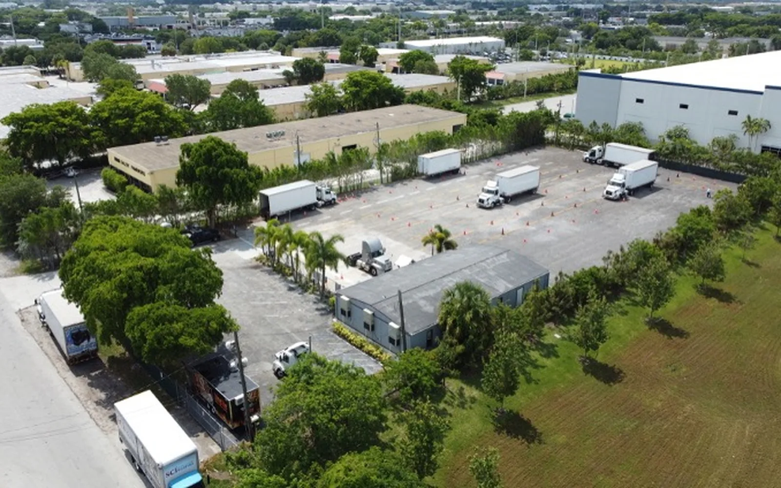 Aerial view of an industrial outdoor storage yard with trucks and trailers
